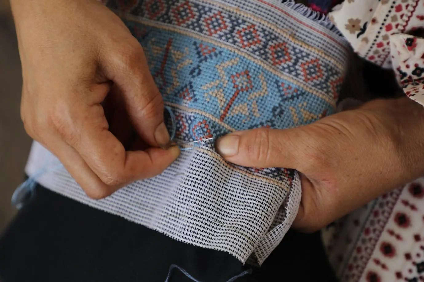 A woman weaving a pattern on fabric